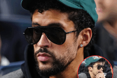 🎤 THE ANTHEM CONTROVERSY (SATIRE): BAD BUNNY FAN THEORY LIGHTS UP YANKEES STADIUM — DID HE REALLY STAY SEATED? 🤔🔥 Fans went wild online after a viral clip appeared to show Bad Bunny staying seated during “God Bless America” at the Yankees-Blue Jays playoff game — but was it real, or just clever editing? 🕵️♂️ The internet exploded with theories, memes, and hot takes, turning a routine ballpark moment into a full-blown cultural debate. ⚾💥 Was it a statement, a misunderstanding, or just social-media chaos doing what it does best? Here’s how the rumor started — and what really happened behind the viral storm.
